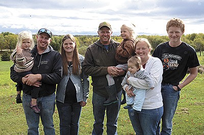 The Elsenpeter families – (from left) Luke holding Irene and Liz; and Dan holding Pearl, Erica holding Norman, and Henry – milk 150 cows near Maple Lake, Minnesota. In 2019, the family dairy was recognized as a sesquincentennial farm. Not pictured are Luke and Liz’s children Evelyn, June and John; and Dan and Erica’s children George, Harvey, Ralph, Dorothy and Leroy. PHOTO BY JENNIFER COYNE