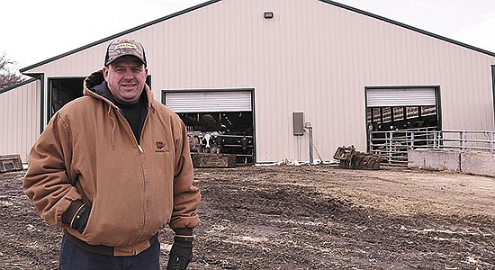Brent Ziegler stands in front of the freestall barn he rebuilt after the previous barn’s roof was weakened during a snowstorm in March 2019. Ziegler milks 280 cows on his dairy near Green Isle, Minnesota.  PHOTO BY KRISTA KUZMA