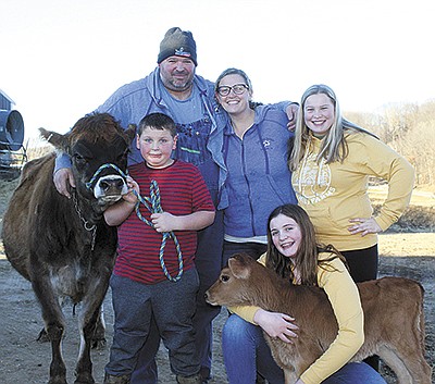 The Kolodzienski family – (front row, from left) Lane and Ava; (back row, from left) Jake, Kristen and Morgan – milks 50 cows on their farm near Beldenville, Wisconsin.  PHOTO BY DANIELLE NAUMAN