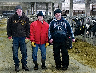 Michael and Theresa Kolb, pictured with Danilo, the farm’s AI technician, breed for longevity and high production on their 450-cow dairy near Paynesville, Minnesota.  PHOTO BY DANNA SABOLIK