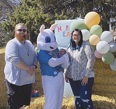 Betsy Kasper, dressed in the Easter bunny costume, holds Otto Elmore accompanied by his parents, Cayden and Courtney, April 3 at the on-farm Easter event the Kaspers had on their dairy near Owatonna, Minnesota.  PHOTO SUBMITTED