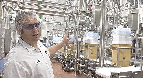 Jared Terning, First District Association cheese plant manager, describes the automated barrel fill line June 30 at the plant in Litchfield, Minnesota. The plant is a part of the cooperative’s expansion to accommodate 7.5 million pounds of milk per day. PHOTO BY JENNIFER COYNE