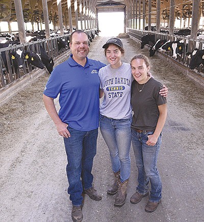Ross Greden and his daughters – Lydia (center) and Megan – stand in one of the freestall barns where they house their 550-cow herd on their dairy, Greden’s Ponderosa Dairy, near Altura, Minnesota. The Gredens’ herd as a pregnancy rate of 39%.  PHOTO BY KRISTA KUZMA