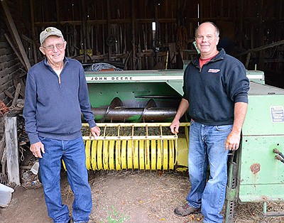 Lewis Hintz (left) and dairy farmer Rob Stone visit at Hintz’s farm near Omro, Wisconsin. Hintz has a reputation for being the best in the area at fixing John Deere and New Holland small square balers. PHOTO BY STACEY SMART