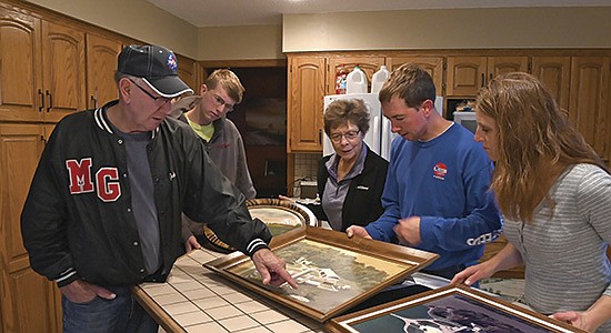 The Nathe family – (from left) John, Payton, Ginny, Jeron and Brenda – look through framed farm photos Oct. 27 at the dairy near Melrose, Minnesota. The Nathes have dairy farmed in central Minnesota for 153 years.  PHOTO BY JENNIFER COYNE