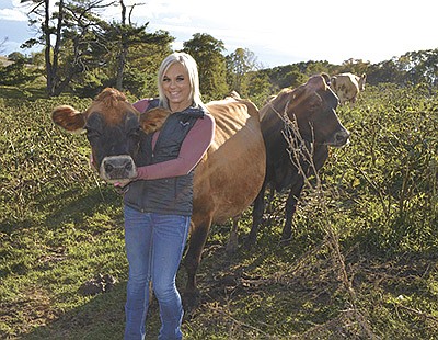 Ashlee Crubel poses with one of her show cows on her farm near Lancaster, Wisconsin. Crubel milks 73 cows, and has been dairying on her own since March 2012. PHOTO BY ABBY WEIDMEYER