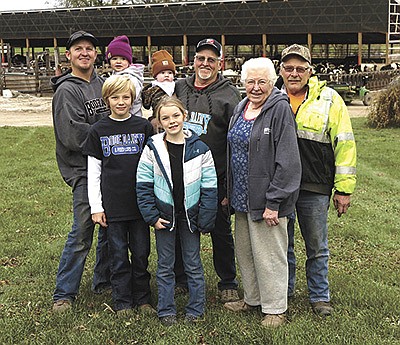 The Bode family – (front, from left) Griffin, Gretta and Lois; (back, from left) Cody, holding Ella, Arlen, holding Rhett, and Vance – milk 600 cows near Gibbon, Minnesota. For almost two decades the family has been enrolled in the Minnesota Dairy Initiative program. PHOTO BY RUTH KLOSSNER