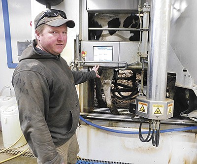 Mike Redalen explains the robots on his farm Dec. 13 near Fountain, Minnesota. Redalen milks 200 cows. PHOTO BY KATE RECHTZIGEL