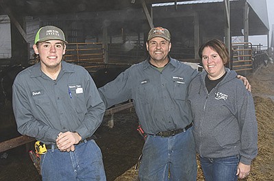 Derek, Anthony and Sherry Anderson stand along a feed corral Dec. 15 on their dairy near Henning, Minnesota. They milk 480 cows.  PHOTO BY MARK KLAPHAKE