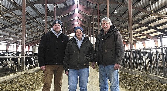 Tyler, Bridget and Roy Siemen stand in their 250 cow freestall near Merrill, Wisconsin. The Siemens moved to the farm in 2017 in order to expand their farming business, allowing Tyler to farm full time with his parents.  PHOTO BY KATI KINDSCHUH