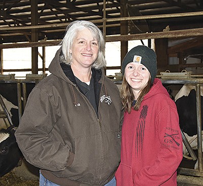 Lisa Groetsch and Clara Pflueger stand in the freestall barn April 14 at Groetsch Dairy near Albany, Minnesota. Pflueger has several responsibilities on the farm.  PHOTO BY MARK KLAPHAKE