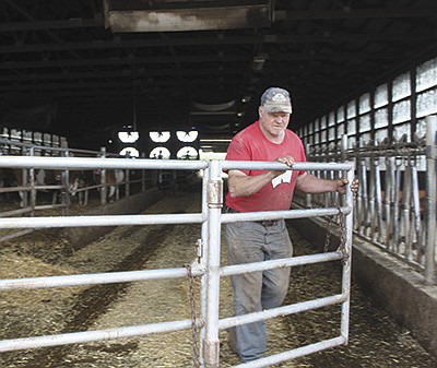 Roy Grewe shuts gates after bedding the pack barn at Valley Gem Farm May 19 near Cumberland, Wisconsin. PHOTO BY DANIELLE NAUMAN
