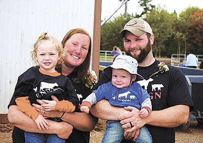 The Ensigns – (from left) Taylor holding Edlin and Evan holding Tommy – dairy farm near Dorchester, Wisconsin. The Ensigns hosted the Abbotsford FFA Alumni Dairy Breakfast June 5. PHOTO BY DANIELLE NAUMAN