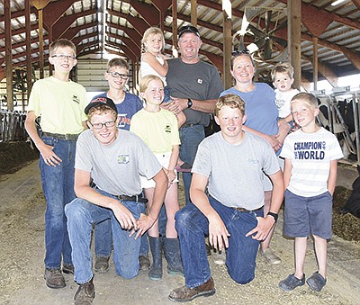 The Elsenpeter family – (front, from left) Henry, George and Leroy; (back from left) Harvey, Ralph, Dorothy, Dan holding Pearl and Erica holding Norman – milk 180 cows near Maple Lake, Minnesota. PHOTO BY MARK KLAPHAKE