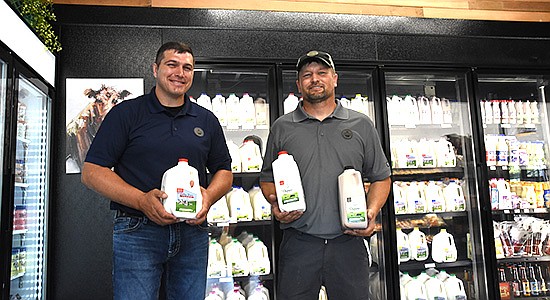 Dairy farmers Justin Malone (left) and Peter Mursu of Smoky Hills Farmers Cooperative stand in their new store June 24 in Hastings, Minnesota. The coop processes both organic and conventional milk. PHOTO BY KATE RECHTZIGEL