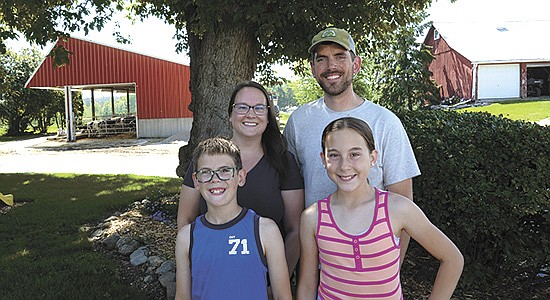  Mitchell and Amanda Schaefer are pictured with two of their three children – Clay and Allison – on their farm where they milk 230 cows and farm 400 acres near Chilton, Wisconsin. Not pictured is the Schaefers’ son, Levi. STACEY SMART