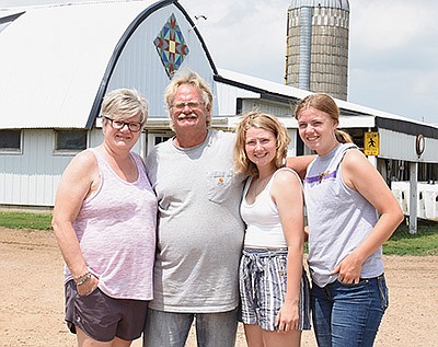 The Steinhagen family – (from left) Lori, Gary, Greta and Martha – stand in front of their barn at their dairy near Belle Plaine, Minnesota. The Steinhagens spoke about hiring out custom work during an on-farm tour July 5. PHOTO BY KATE RECHTZIGEL