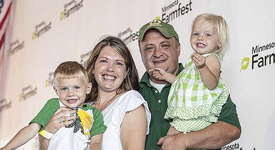 Kristin Reiman-Duden celebrates with her family – (from left) Cordell and Thomas Duden holding Marilyn – after being named the 2022 Woman Farmer of the Year at Farmfest Aug. 4 in Morgan, Minnesota. Reiman-Duden dairy farms near Princeton, Minnesota. Photo Courtesy of Philip Gerlach of Minnesota Farmfest 