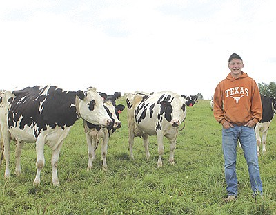 Austin Fahey stands among his family’s herd of registered Holstein cows Aug. 19 on their organic dairy farm in Edgar, Wisconsin, Aug. 19. Fahey was the winner of the Wisconsin FFA State Organic Agriculture Proficiency earlier this summer at the state FFA convention.  PHOTO BY DANIELLE NAUMAN
