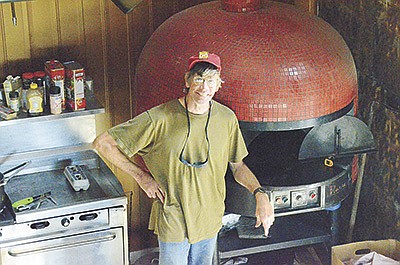 Steve Lawless stands by the pizza oven Aug. 16 at Sittin’ Pretty Pizza Farm near Viroqua, Wisconsin. Lawless runs the pizza farm as a nonprofit to support local farmers and businesses.  PHOTO BY ABBY WIEDMEYER