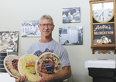 Rusty Mitch displays several varieties of pizza and cheese fries that Portesi Italian Foods markets in Wisconsin. Mitch is the third generation to operate the company based in Stevens Point, Wisconsin. PHOTO BY DANIELLE NAUMAN