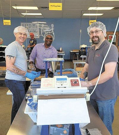 Bongards employees Bob Grinsell (from left), Ranjeeth Swagatha and Justin Rudd assemble nutritious meals Sept. 20 at Feed My Starving Children in Chanhassen, Minnesota. The meals are sent to organizations across 70 countries.  PHOTO SUBMITTED