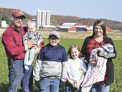 The McCullough Family – Jonathon (from left) holding Waylon, Wyatt, Kassidy and Emily holding Korbin – stand on their farm Oct. 22 near Hustler, Wisconsin. They milk 45 cows. PHOTO BY ABBY WIEDMEYER