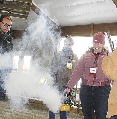 Courtney Halbach uses a fogger to demonstrate how air flows in a calf barn Oct. 25 during a Professional Dairy Producers Calf Care Connection presentation at Dutch Dairy in Thorp, Wisconsin. The presentation focused on how important ventiliation is in heifer facilities.                                                                               PHOTO BY DANIELLE NAUMAN