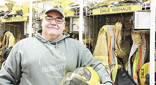 Dale Niehaus holds his helmet Nov. 11 at the fire station in Osakis, Minnesota. Niehaus milks 100 cows and is a member of the city’s fire department. PHOTO BY MARK KLAPHAKE