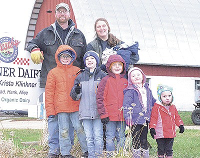 The Klinkner family – Liam (front, from left), Brad, Hank, Alice and Tressa; (back, from left) Travis and Krista holding Aiden – stand together Nov. 12 on their farm near Genoa, Wisconsin. The Klinkners milk 60 cows. PHOTO BY ABBY WIEDMEYER