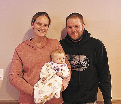 Amber and Jeremiah Pung hold their daughter Eden Dec. 15 at their dairy farm near Freeport, Minnesota. Amber and Jeremiah met at Ridgewater College while pursuing degrees in dairy management. PHOTO BY TIFFANY KLAPHAKE