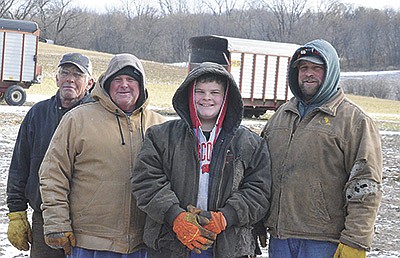 Tom Johnson (from left) stands with his family Brad, Heath and Ryan Johnson Dec. 7 at their farm near Osseo, Wisconsin. The Johnsons milk 100 cows in a herringbone parlor. PHOTO BY ABBY WIEDMEYER