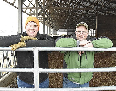 Carter Roerick and his dad, Allen, stand in a monoslope barn Jan. 23 on their farm near Freeport, Minnesota. Carter, a senior at Melrose High School, helps his dad and uncle, Gerald Roerick, on the farm where they milk 80 cows.  PHOTO BY MARK KLAPHAKE