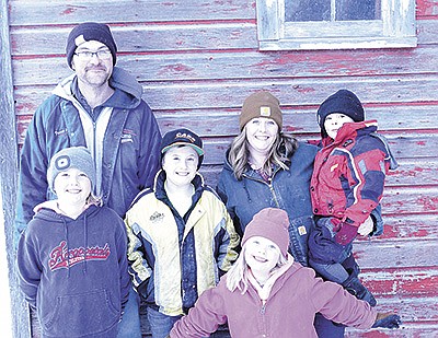 Kevin and Jamie Hemmesch gather with their children – Ellie (from left), Ethan, April and Aiden – on their farm near Lake Henry, Minnesota. The Hemmesches milk 63 cows in a tiestall barn. PHOTO BY TIFFANY KLAPHAKE