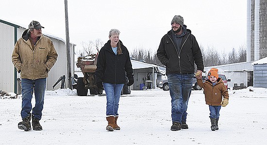 Scott (from left), Darlys, Dallas and Myles Albrecht visit as they walk across their yard Jan. 18 on their farm near Mizpah, Minnesota. The Albrechts milk 90 cows and are the last dairy in Koochiching County. PHOTO BY MARK KLAPHAKE