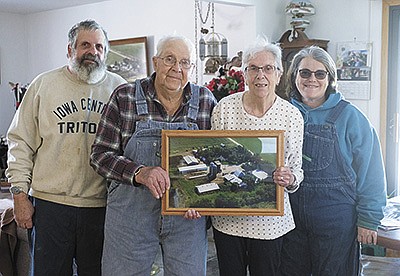 Glenn Davis (from left) and his parents, Lawrence and Lois Davis, and Glenn’s partner, Tracie Phillips, display the most recent aerial photograph of their farm Feb. 7 near Gilmore City, Iowa. Glenn and his brother, Bruce (not pictured), are the third generation on the family’s farm. PHOTO BY AARON THOMAS