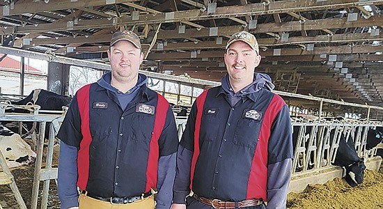 Brady (left) and Brett Weiland milk 1,150 cows near Columbus, Wisconsin. The Weilands use forward contracting to ensure profitability and have 75% of their milk contracted for 2023. PHOTO BY STACEY SMART