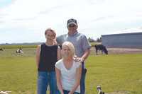 Dave and Kristi Tveten, pictured with their daughter Jacki, are the third generation in their family to farm. Although others were skeptical about the Tvetens’ ability to farm without land when they began dairying in 1977, the family has made it through challenges with support from their family and a passion for the dairy industry. (photo by Krista M. Sheehan)