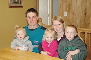 Joel Hendrickson is pictured with his wife, Amanda, and their three children, (from left) Julia (1), Madelyn (2) and Zachary (4). Although Joel generally takes care of the dairy, Amanda has milked for him a few times, allowing him the chance to spend time with their kids. (photo by Jennifer Burggraff)