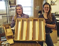 Tricia and Karisa Neels display the soap mold that was created from an old knickknack rack, along with a homemade jig for cutting their soap into bars. The Neels family has been making and selling goat milk soap for the past four years.<br /><!-- 1upcrlf -->PHOTO BY JERRY NELSON