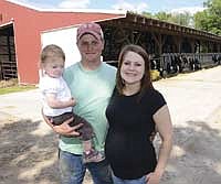 Andrew (holding Ellie, 1) and Chelsa Golberg are pictured on their 125-cow dairy near Deer Creek, Minn. The couple has been farming since 2005 and said they have encountered several challenges in their dairying career. The couple is expecting their second child in August.<br /><!-- 1upcrlf -->PHOTO BY MARK KLAPHAKE