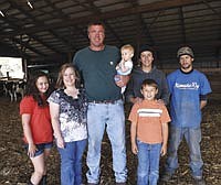 The Nuytten family milks 140 head on their 650-acre organic operation located near Hazel Run, Minn. They include Grace (11), Amber, Jerry, Faith (10 1/2 months), and Matthew, (8). Also pictured are hired men Jorge Juina and Cody Steckelberg. Juina, who is from Ecuador, is a trainee that came to the Nuytten farm via Global Cow.<br /><!-- 1upcrlf -->PHOTO BY JERRY NELSON