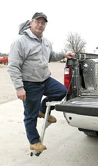 Myron Isaacson demonstrates the pickup bed ladder he invented to allow easy access to the bed of his new pickup. The aluminum steps are made to carry up to about 300 pounds.<br /><!-- 1upcrlf -->PHOTO BY RUTH KLOSSNER