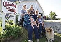 The Alderinks sit outside their 32-cow tiestall barn on their 80-acre farm near Grasston, Minn. Sue is holding granddaughter, Amelia. Jeff is holding granddaughter, Matilda. Back row is Maddy and daughter-in-law, Kristen.<br /><!-- 1upcrlf -->PHOTO BY MARK KLAPHAKE