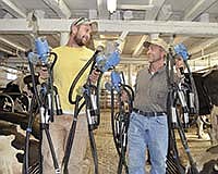Randy Abel (right) and his son, Derek (23) carry the milking units into the barn on Oct. 7. The Abels milk 65 cows on their farm near Buffalo in Wright County, Minn. <br /><!-- 1upcrlf -->PHOTO BY MISSY MUSSMAN