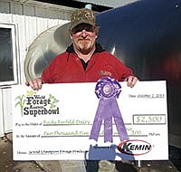 Doug Kerfeld holds a mock check presented to him after his haylage entry won Grand Champion honors in a World Dairy Expo competition on Oct. 1.<br /><!-- 1upcrlf -->PHOTO Y RANDY OLSON