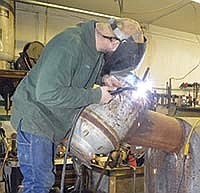 Scott Balzer welds an ear on a cow he is working on in his shop. In between chores, Balzer can be found in his shop, working on different projects. <br /><!-- 1upcrlf -->PHOTO BY KRISTA KUZMA