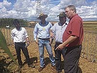 John Maxwell (right) visits with Brazilian farmers during a recent trip to Brazil. Maxwell milks 260 cows on his family’s farm near Donahue, Iowa. <br /><!-- 1upcrlf -->PHOTO SUBMITTED