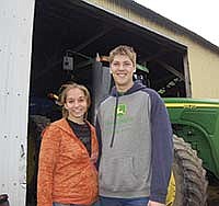 Friends, Brook Teague and Jared Capko, stand next to the tractor they took to their high school prom just days earlier. <br /><!-- 1upcrlf -->PHOTO BY ANDREA BORGERDING