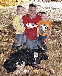 Jared Kruger, along with his sons, Nolan (5) and McCoy (2), are shown with the two-headed Holstein calf born on May 19. The Krugers milk 300 cows near Wabasha, Minn. <br /><!-- 1upcrlf -->PHOTO SUBMITTED